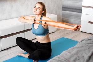 kvinna som försöker gå ner i vikt och träna med elastiskt band foto