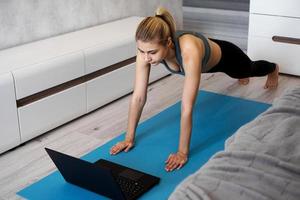 fitness flicka träna titta på online -videor på bärbar dator foto