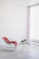 bekväm röd fåtölj och soffbord med koppar i vardagsrummet foto