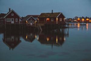 norge rorbu hus och berg stenar över fjorden foto