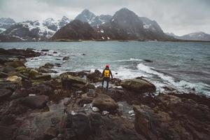 resenärsfotograf på stenar mot bakgrund av hav och berg