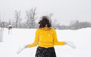 ung brunettkvinna som leker med snö i parken foto