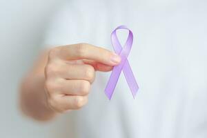 kvinna innehav lila band för mage, våld, pankreas, esofagus, testikulär cancer, alzheimer, epilepsi, lupus, sarkoidos och fibromyalgi. medvetenhet månad och värld cancer dag begrepp foto