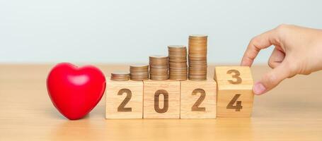 2024 Lycklig ny år för hälsa vård med hjärta form på tabell. pengar sparande, mål, donation, upplösning, hälsa försäkring, wellness och medicinsk begrepp foto