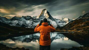 ett person innehav kamera fotografering berg topp foto