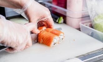 sushi kock skiva rullar foto