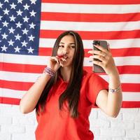 kvinna med en brusmakare som tar en selfie på usa -flaggbakgrunden foto