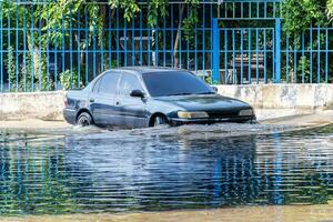 bil körning på översvämmad väg foto