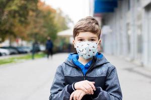 barn bär ansiktsmask i staden under coronaviruspandemin. foto