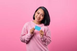 porträtt vacker ung asiatisk kvinna le med kreditkort foto