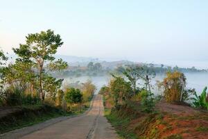 kurva väg motorväg på de berg och dimmig i skog kulle se, Land väg i thailand foto