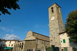 reggello. tuscany område. Italien. september 2023. medeltida kyrka med kapell över blå himmel bakgrund foto