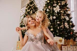 dotter kramar sin mamma medan hon sitter vid jul foto