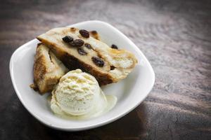 brittisk traditionell brödpudding med vaniljglass efterrätt foto