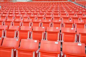 tömma orange säten på stadion, rader av sittplats på en fotboll stadion foto