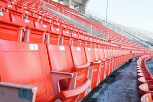 tömma orange säten på stadion, rader av sittplats på en fotboll stadion foto