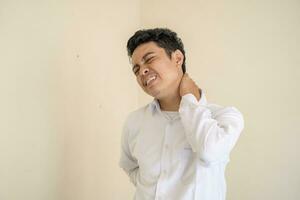 ung indonesiska lockigt man ha på sig vit kläder känna smärtsam. foto