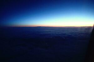 original- soluppgång landskap över mörk moln sett från de fönster av ett flygplan foto