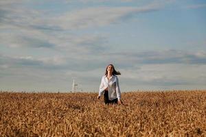 kvinna springer i ett vetefält på en sommardag. lycka och glädje koncept