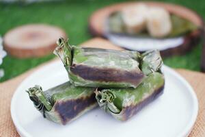 lemper bakar. lemper är en traditionell indonesiska mellanmål tillverkad av klibbig ris och fylld med kyckling kött och insvept i banan löv. selektiv fokus foto