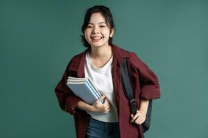 porträtt av en skön asiatisk studerande på en grön bakgrund foto