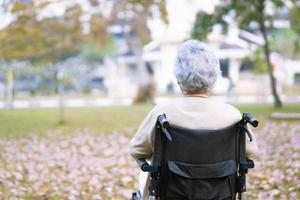 asiatisk senior kvinna patient på rullstol i park foto
