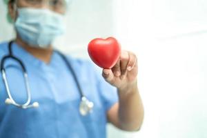 asiatisk läkare bär ppe -kostym för att skydda coronavirus med rött hjärta foto