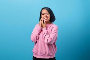 asiatisk kvinna vidrör kinden medan hon lider av fruktansvärd tandvärk