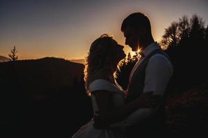 silhuett av gift par vid solnedgången foto