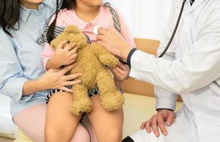 barnläkare undersöker litet barn på sjukhusklinik foto