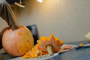 barn snider från en pumpa. familj roligt aktivitet. arved pumpor in i jack-o-lyktor för halloween. träsnideri stor orange pumpor för halloween i sent höst. foto