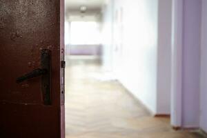 öppen mörk dörr mot ljus tömma korridor av skola. ukrainska skola under coronavirus karantän. plats för text. kopia Plats. skola, utbildning och inlärning begrepp foto