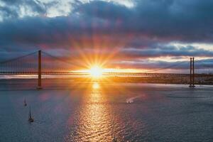 se av 25 de abril bro över tagus flod på solnedgång. Lissabon, portugal foto