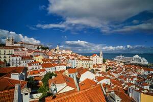 se av lissabon från miradouro de santa luzia synpunkt med förtöjd kryssning liner och rör på sig moln. Lissabon, portugal foto