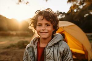 porträtt av en söt pojke ser på kamera medan nära hans tält i natur ai genererad foto