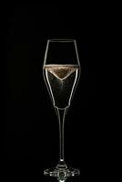 bakgrundsbelyst vin champagne glas med gyllene flytande foto