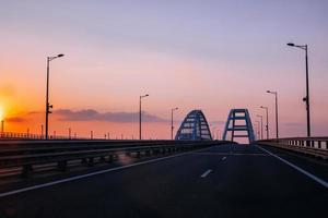 Krimbro över kerch sundet vid kvällssolnedgången foto