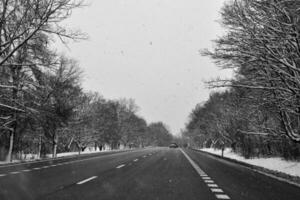 vinter- väg utanför de stad under snöfall foto