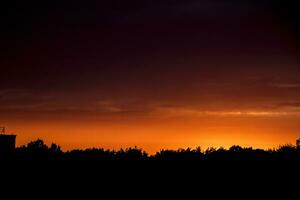 orange sommar himmel med moln under solnedgång foto