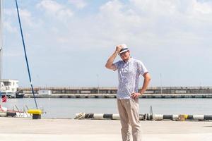 turist som går i havshamnen, båtar och yachter i bakgrunden foto