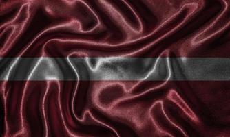 tapeter av Lettlands flagga och viftande flagga av tyg. foto