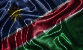 tapet av namibia flagga och viftande flagga efter tyg. foto