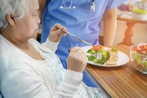 asiatisk senior kvinna patient äter frukost på sjukhus. foto
