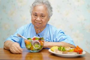 asiatisk senior kvinna patient äter frukost på sjukhus. foto