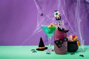 läskiga färgglada halloweencocktails med festdekorationer på lila foto