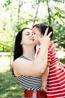 mamma kysser och lugnar sin lilla dotter foto