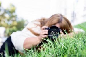 porträtt av överviktig kvinna som tar bilder med en kamera i parken foto