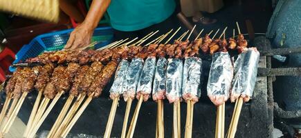 sate buntel eller satay buntel är satay tillverkad från mald fårkött insvept i fårkött fett är varelse grillad på träkol foto