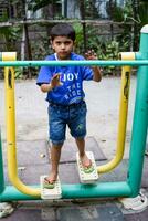 asiatisk pojke håller på med rutin- övning i samhälle parkera under de morgon- tid. söt liten unge övning och Gym till ha kvar han själv passa för liv. barn övning utomhus- skjuta foto