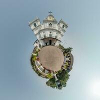 portugal katolik kyrka i djungel bland handflatan träd i indisk tropisk by på liten planet i blå himmel, omvandling av sfärisk 360 panorama. sfärisk abstrakt se med krökning av Plats. foto